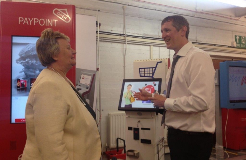 Heather Wheeler MP and Jonathan Portus looking at a self-checkout kiosk machine